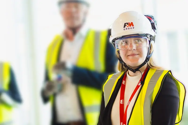 Project team in high-visibility gear walking a construction site