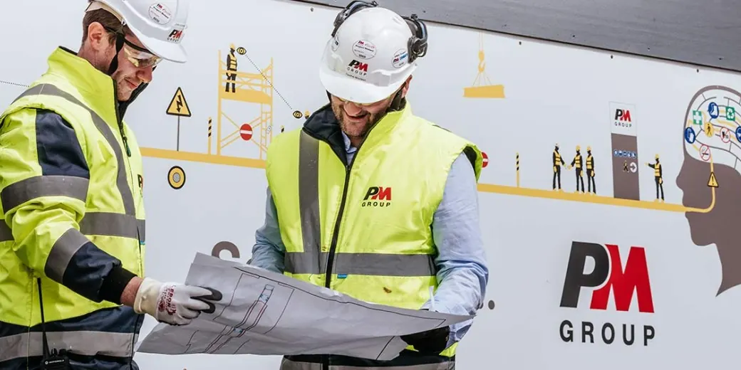 Project team in high-visibility gear walking a construction site